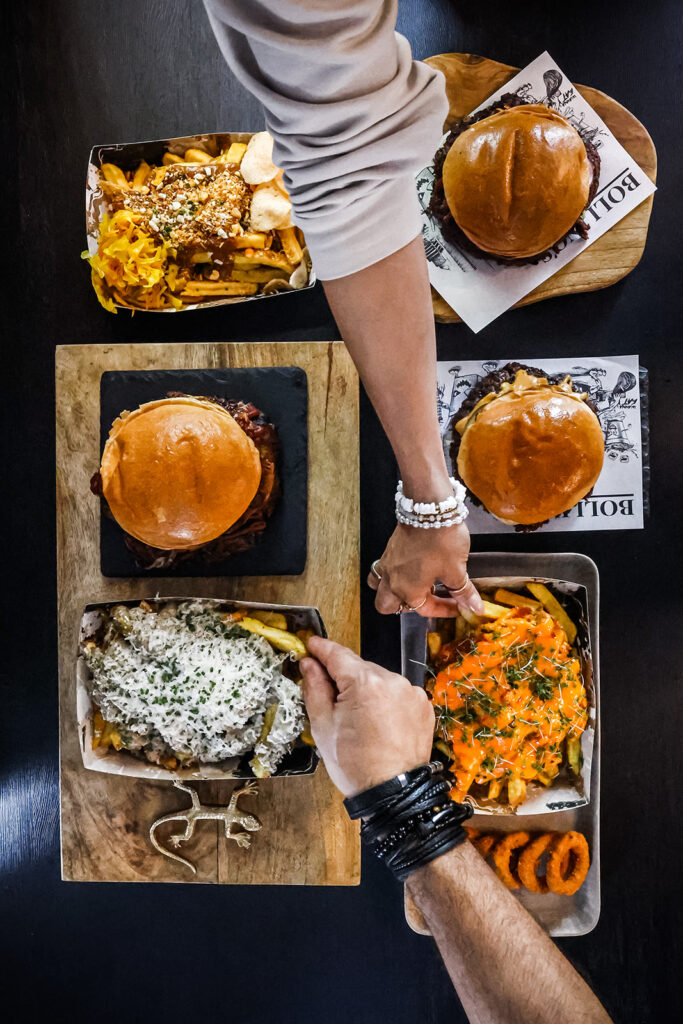 Een tafel die voll staat met eten zoals loaded fries en burgers